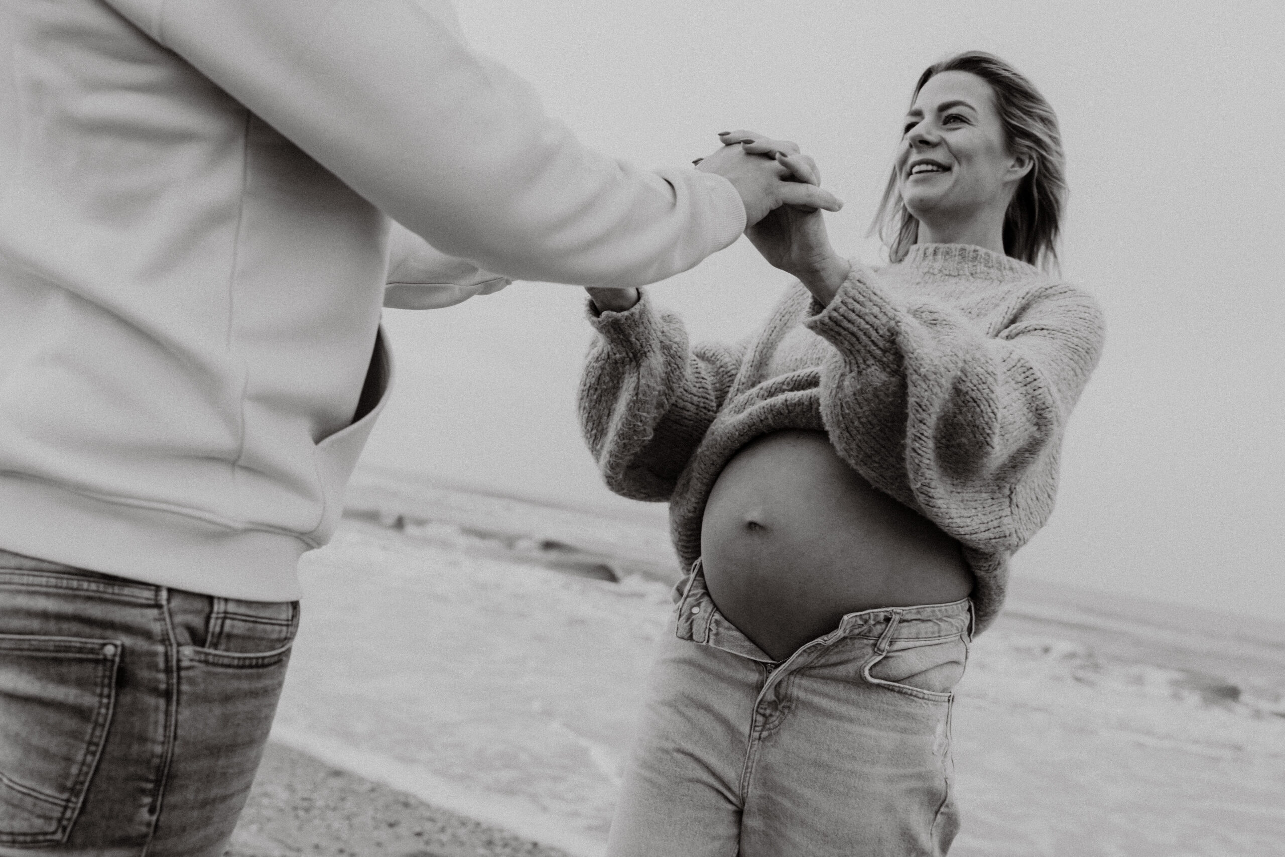 Zwangerschapsshoot strand Katwijk, handen vasthouden